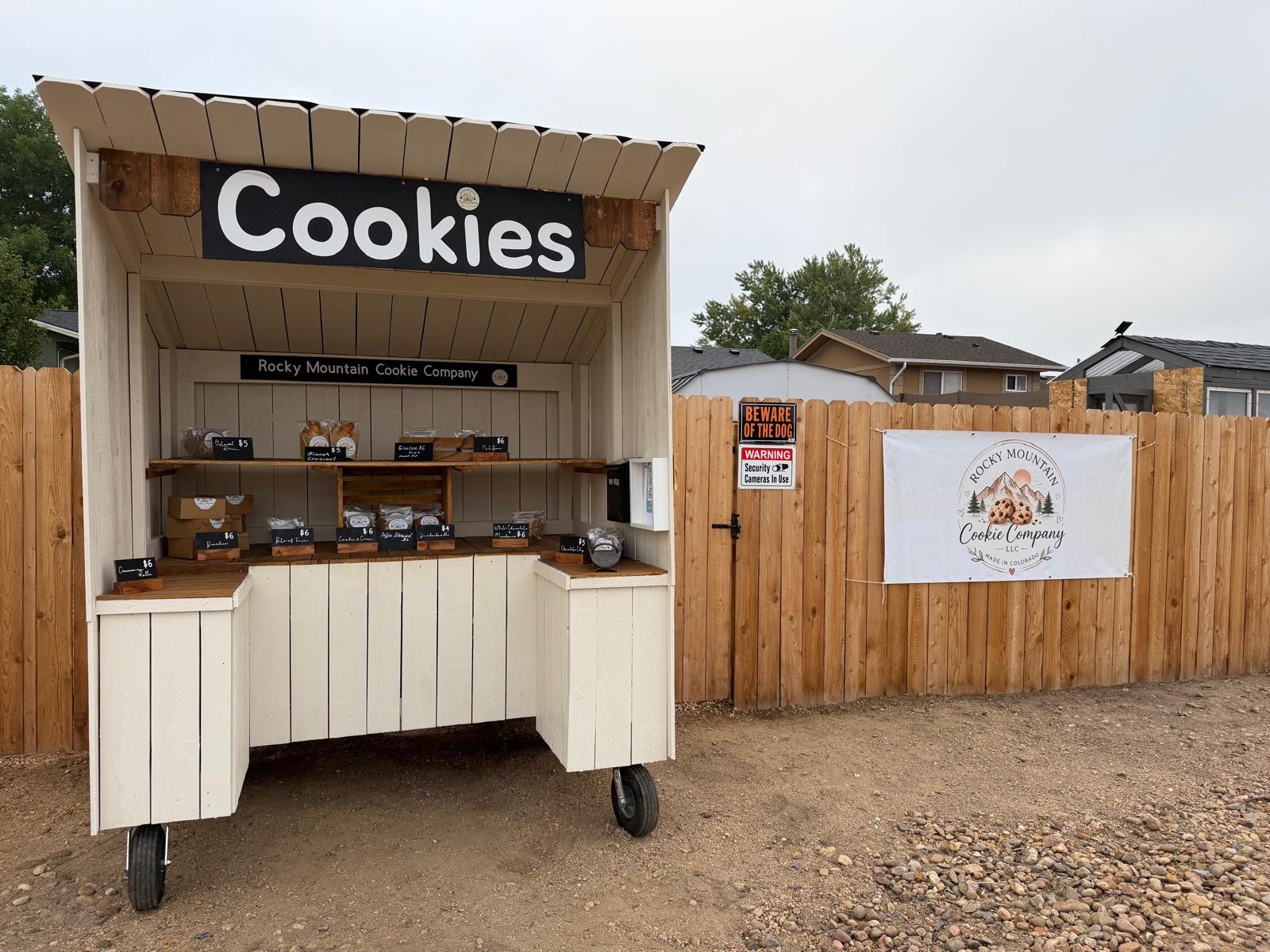 Rocky Mountain Cookie Company honor booth with cookies, outdoors when weather permits
