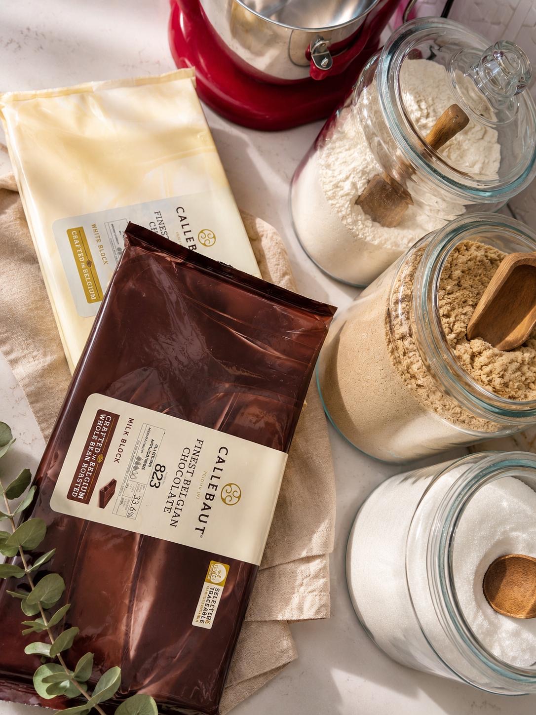 Large jars of sugar and flour with a block of Belgian chocolate